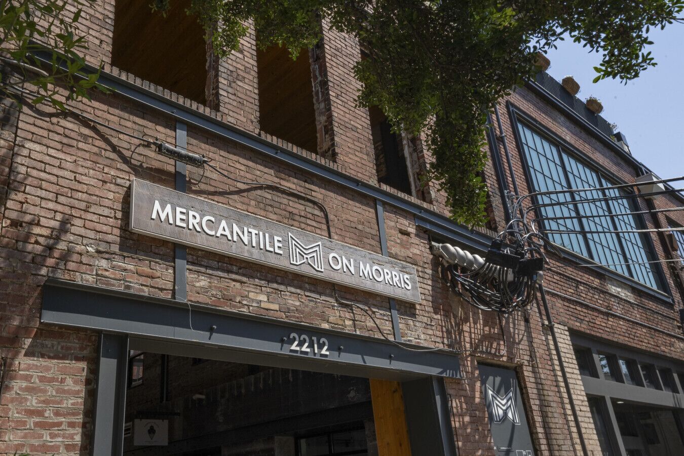 A brick building with a sign that reads "Mercantile on Morris" and the address "2212".