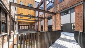 Un bâtiment moderne doté d’une façade en bois, de grandes fenêtres et d’une terrasse en bois.