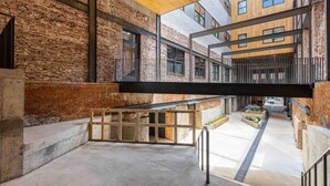 Un intérieur moderne avec des murs en briques apparentes, un plafond en bois et une mezzanine.