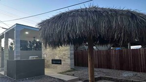 A modern outdoor area with a concrete patio, a stone wall, and a wooden fence. - Charming and Cozy Place (Las Vegas)