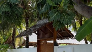 A white wall with a logo and name "Navaya Diffushi" and a wooden door. - Navaya Dhiffushi (Dhiffushi)