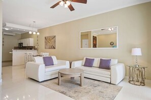 A modern living room with a sofa set, a coffee table, and a dining area in the background. - 2BR Townhouse w/ Pool View, 1 Min to Eagle Beach (Noord)