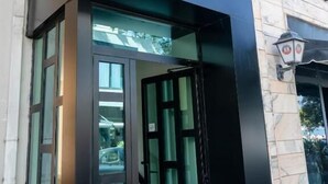 A building entrance with a black facade and a sign that reads "adoré". - Adore Boutique Hotel (Vlorë)
