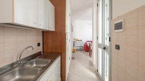 Una cocina moderna con armarios blancos, electrodomésticos de acero inoxidable y una pared de acento de madera.