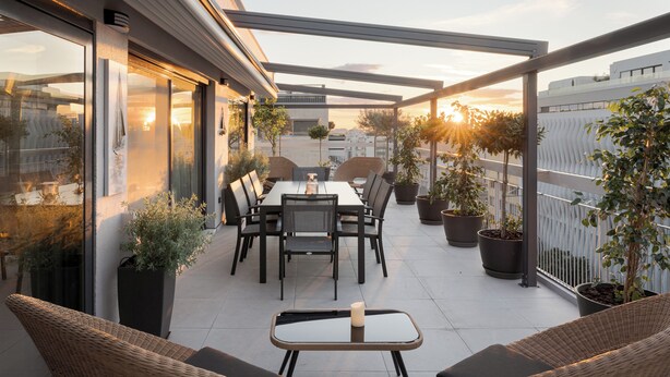 A modern outdoor patio with a dining table, chairs, and potted plants. - Athens Golden Light Premium Residence (Athens)
