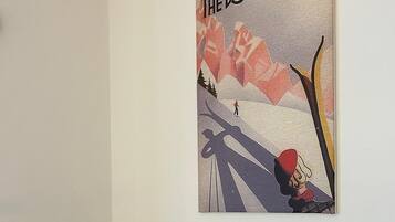 Ein Zimmer mit einem Bett, drei Kissen und einem Poster an der Wand.