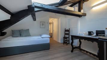 Une chambre avec un lit, un coin café et une chaise en bois.