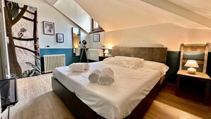 Una moderna camera d'hotel con un letto grande, una scrivania, una sedia e una finestra con vista sul cielo.