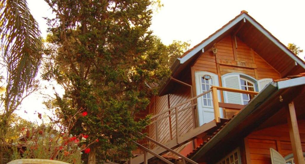 Une maison en bois dotée d’un balcon et d’un escalier menant à l’étage supérieur.
