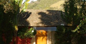 Escape to a serene, natural haven surrounded by lush greenery and a charming wooden door.