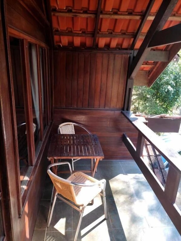Relax in this serene outdoor seating area with a table and two chairs, surrounded by lush greenery.