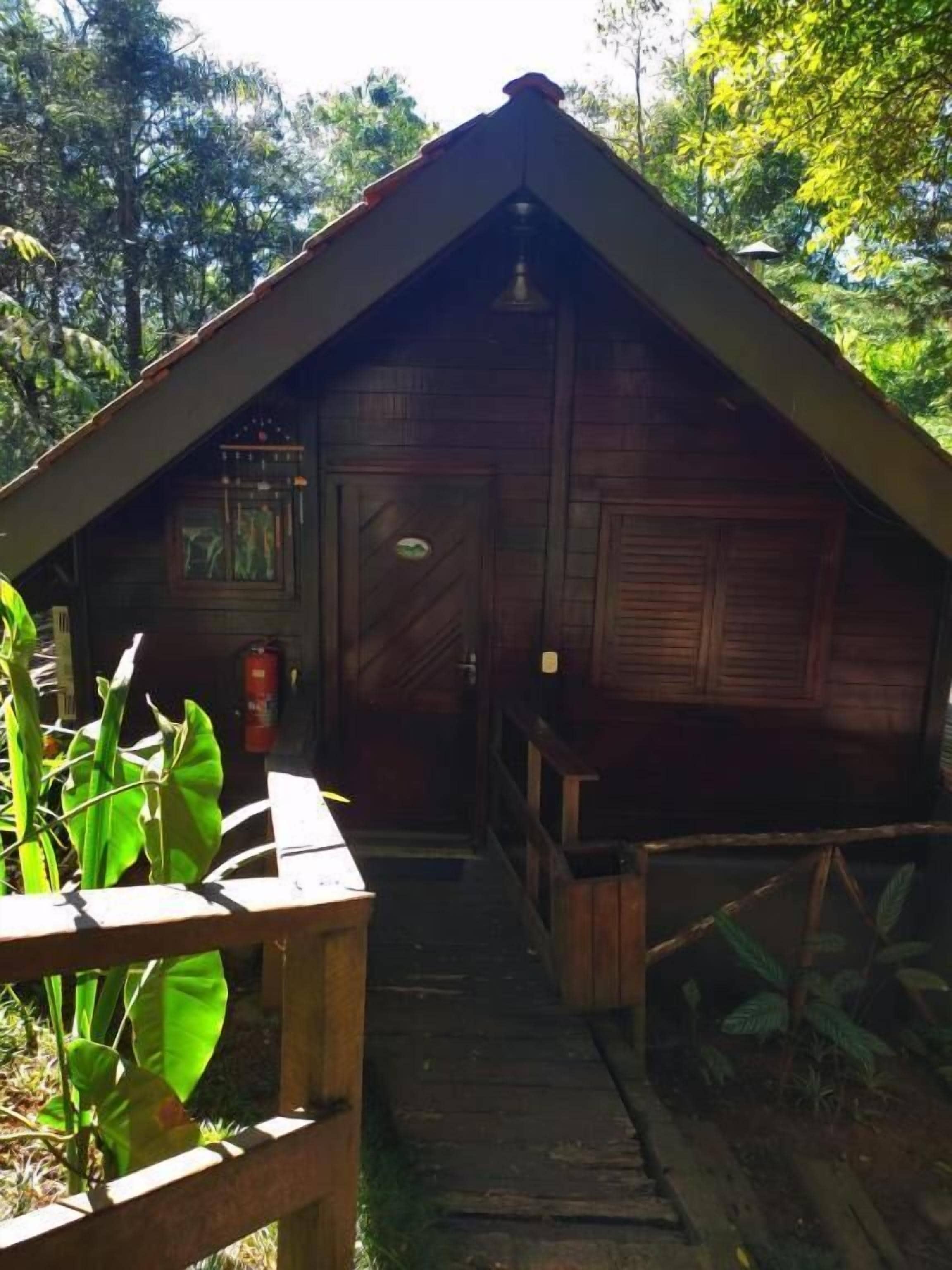 A wooden cabin with a sloped roof, a front door, and a small porch area.
