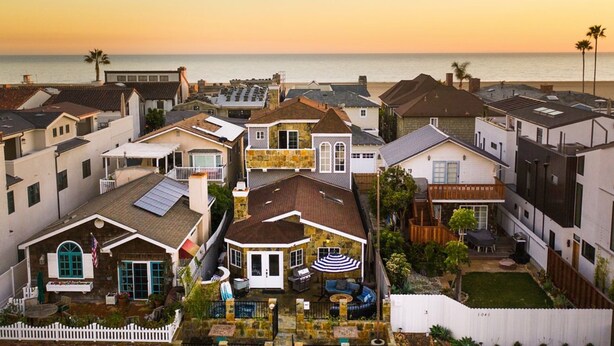 A residential area with houses, a patio, and a view of the ocean at sunset. - Sand Castle by Avantstay Beach House on Balboa Peninsula w Patio Hot Tub (Newport Beach)