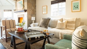A cozy living room with a fireplace, a sofa, a coffee table, and a game table. - Sand Castle by Avantstay Beach House on Balboa Peninsula w Patio Hot Tub (Newport Beach)
