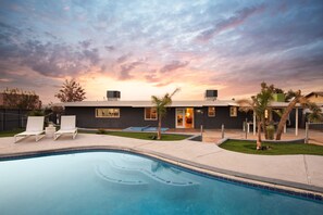 A modern house with a swimming pool, two lounge chairs, and a well-maintained lawn. - Jackrabbit Ridge by Avantstay Entertainers Paradise w Pool Games (Twentynine Palms)