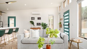 A modern living room with a grey sofa, a coffee table, and a potted plant. - Chicory by Avantstay Modern Desert Retreat w Hot Tub (Joshua Tree)