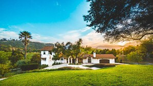 A two-story house with a large lawn, a garage, and a tree in the foreground. - De Luz by Avantstay 5 Acre Estate w Lake Pool Hot Tub (Temecula)