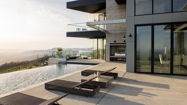 A modern building with a rooftop infinity pool, outdoor seating, and a scenic view. - Belleza by Avantstay Hilltop Mansion w Pool Panoramic Views Ultra Modern Interior (Glen Ellen)
