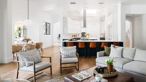 A spacious living room with a sofa, chairs, a coffee table, and a dining area with a table and chairs. - Villa Verbena by Avantstay Expansive Estate w B-ball Court Pool Spa Entertainer s Yard (Indio)