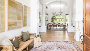 A spacious living area with a sofa, a patterned rug, and a dining area in the background. - Villa Verbena by Avantstay Expansive Estate w B-ball Court Pool Spa Entertainer s Yard (Indio)