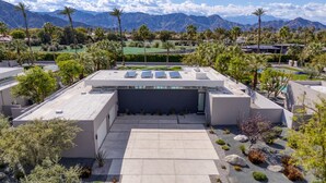 A rooftop with solar panels, a pool, and a view of mountains.