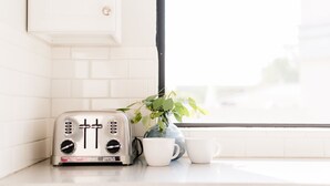 A kitchen with a toaster, two white cups, and a potted plant. - Ivory II By Avantstay Gorgeous Spacious Home w Views Close To Old Town (Scottsdale)