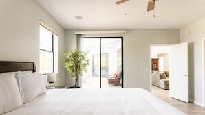 A spacious bedroom with a large bed, a potted plant, and a view of a balcony. - Ivory II By Avantstay Gorgeous Spacious Home w Views Close To Old Town (Scottsdale)