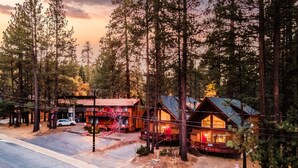 A lodge with a rustic wooden exterior, a covered porch, and a car parked outside. - Jumper By Avantstay Serene Stylish Cabin w Hot Tub (Big Bear Lake)