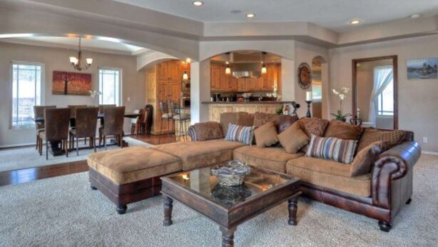 A spacious living room with a large sectional sofa, a coffee table, and a dining area with chairs and a table. - Boulder Bay Lodge by Avantstay Boulder Bay Home w Hot Tub Large Patio Game Room (Big Bear Lake)