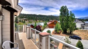 A balcony with a view of a residential area, including houses and a road. - Boulder Bay Lodge by Avantstay Boulder Bay Home w Hot Tub Large Patio Game Room (Big Bear Lake)