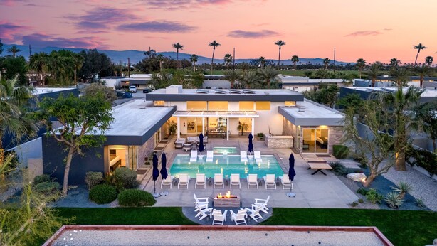 Un hôtel moderne doté d’une piscine, de chaises longues et d’un jardin bien entretenu.