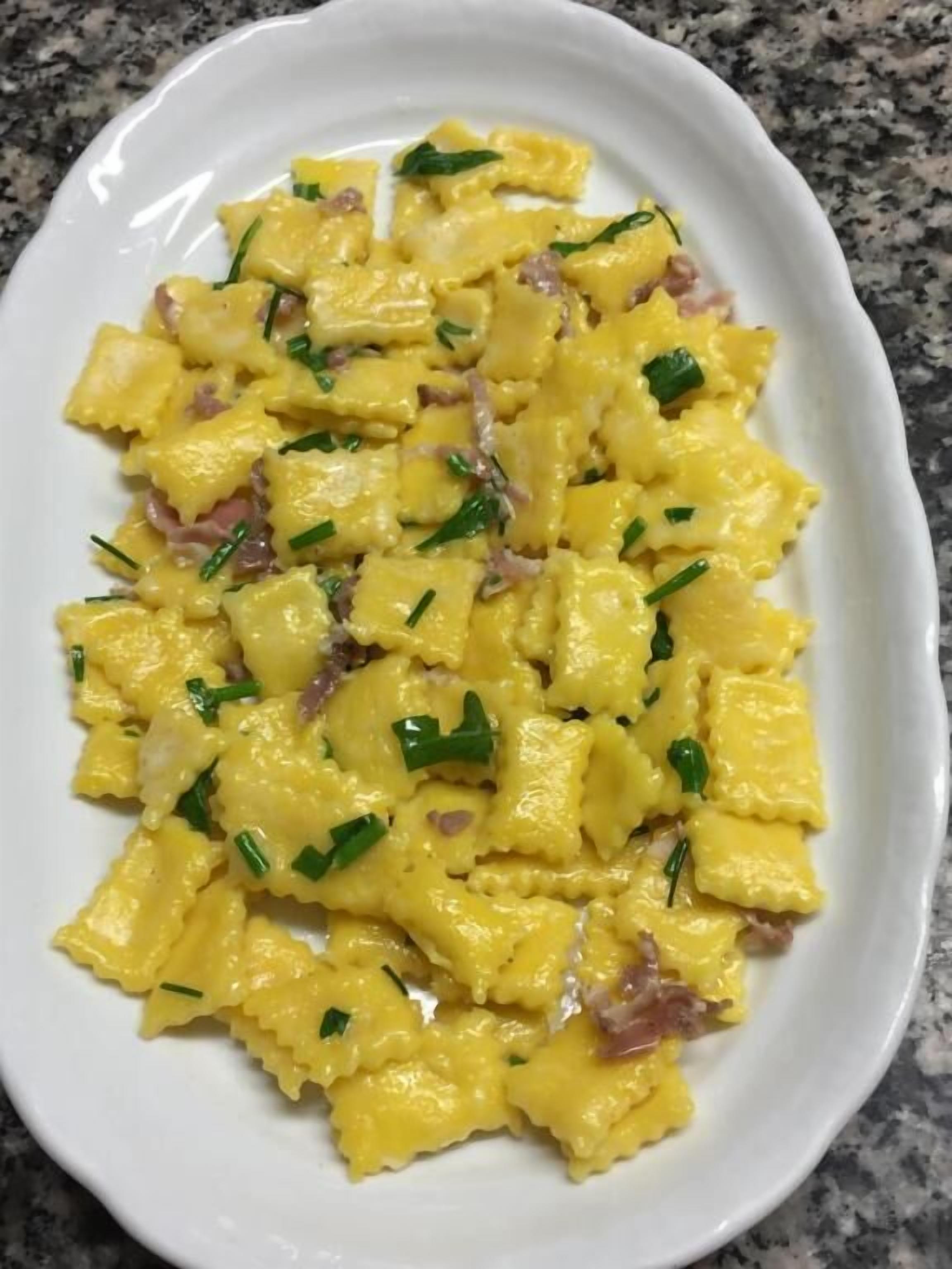 Une assiette ovale blanche contenant un plat de pâtes.