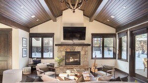 A cozy living room with a stone fireplace, a large flat-screen TV, and comfortable seating. - Maple by Avantstay Modern Mountain Home w Cozy Fire Pit 15 Mins frm Northstar (Truckee)