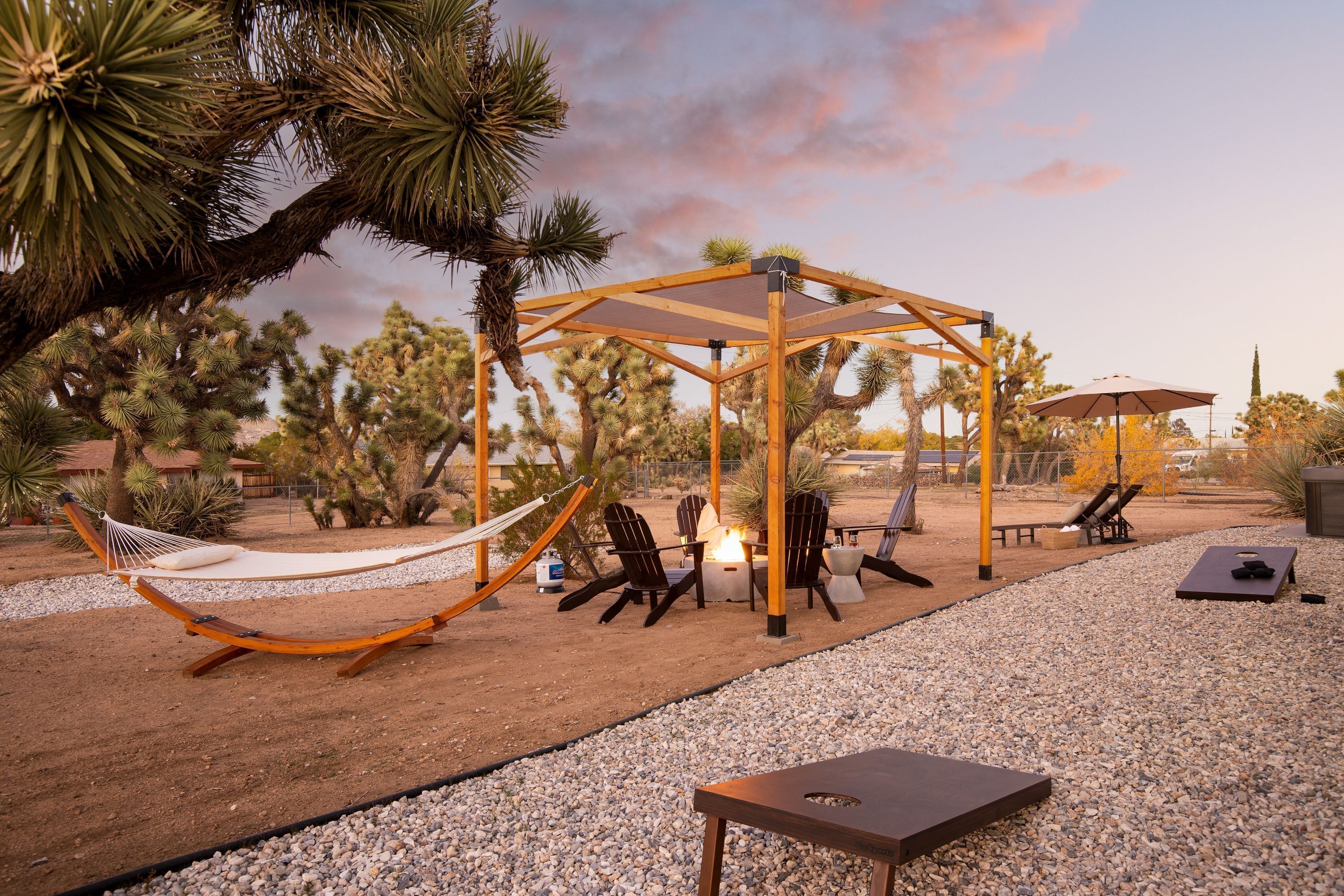 Un hamac, des sièges d’extérieur et une pergola dans un jardin de style désertique.
