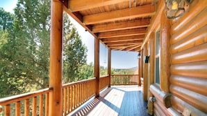 A wooden deck with a railing, overlooking a forested area. - Starlight Retreat by Avantstay Gorgeous Log Style Home w Incredible Views (Big Bear Lake)
