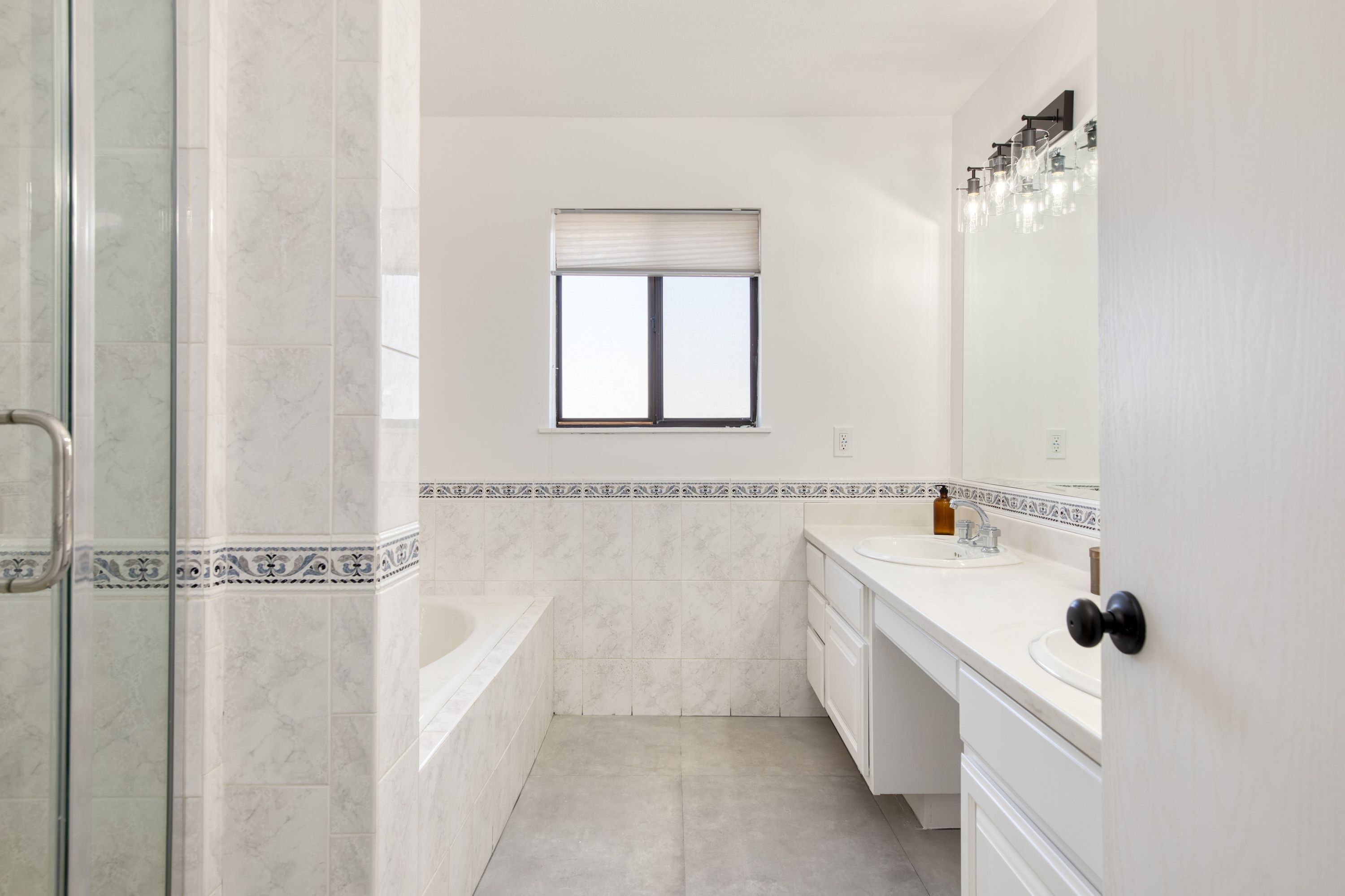 Une salle de bain avec une douche à parois de verre, une baignoire, un lavabo et un meuble-vasque.