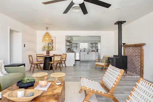 A modern living room with a dining area, a kitchen, and a fireplace. - Asteroid by Avantstay Unique Ranch Retreat Just Outside Joshua Tree Permit Vhr22-094 (Twentynine Palms)
