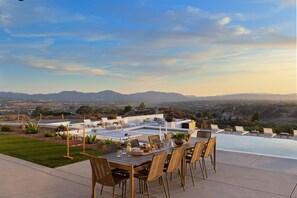 A rooftop dining area with a table set for four, overlooking a mountainous landscape. - Pinot Point by Avantstay Massive Estate 10 Mins From Temecula Wineries (Temecula)