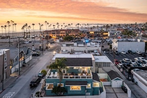 A coastal urban area with a mix of commercial and residential buildings, including a prominent hotel with a rooftop pool and a view of the beach. - Sea Sight by Avantstay Walk to Newport Beach (Newport Beach)