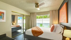 A hotel room with a bed, a desk, a chair, a ceiling fan, and a view of the outside. - Biskra by Avantstay Classic Palm Springs Getaway W Outdoor Living Pool Permit 4869 (Palm Springs)
