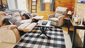 A cozy living room with a sofa, armchairs, a coffee table, and a checkered rug. - Cozy 2-bedroom cabin in welcoming Sangerville with WiFi (Sangerville)