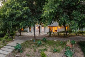 A house with a paved driveway, surrounded by lush greenery and trees. - Quarter Horse by Avantstay Countryside Retreat (Temecula)