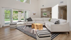 A spacious living room with a large sectional sofa, a wooden coffee table, and a patterned rug. - Quarter Horse by Avantstay Countryside Retreat (Temecula)