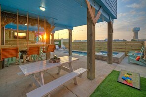 En udendørs terrasse med træmøbler, en pool og udsigt over landskabet.