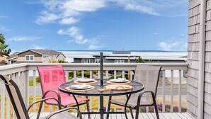 A deck with a round table and chairs, overlooking a residential area and the ocean. - Beach Lookout Retreat by Avantstay Rooftop Views (Coupeville)