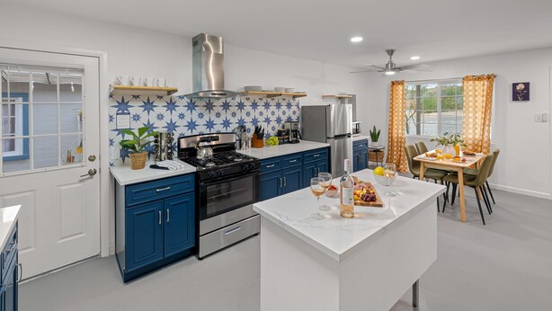 A modern kitchen with blue cabinets, a white countertop, and a central island. - Fable by Avantstay 2 Unique Spaces w Bowling Hot Tub Fire Pit Large Yard (Joshua Tree)