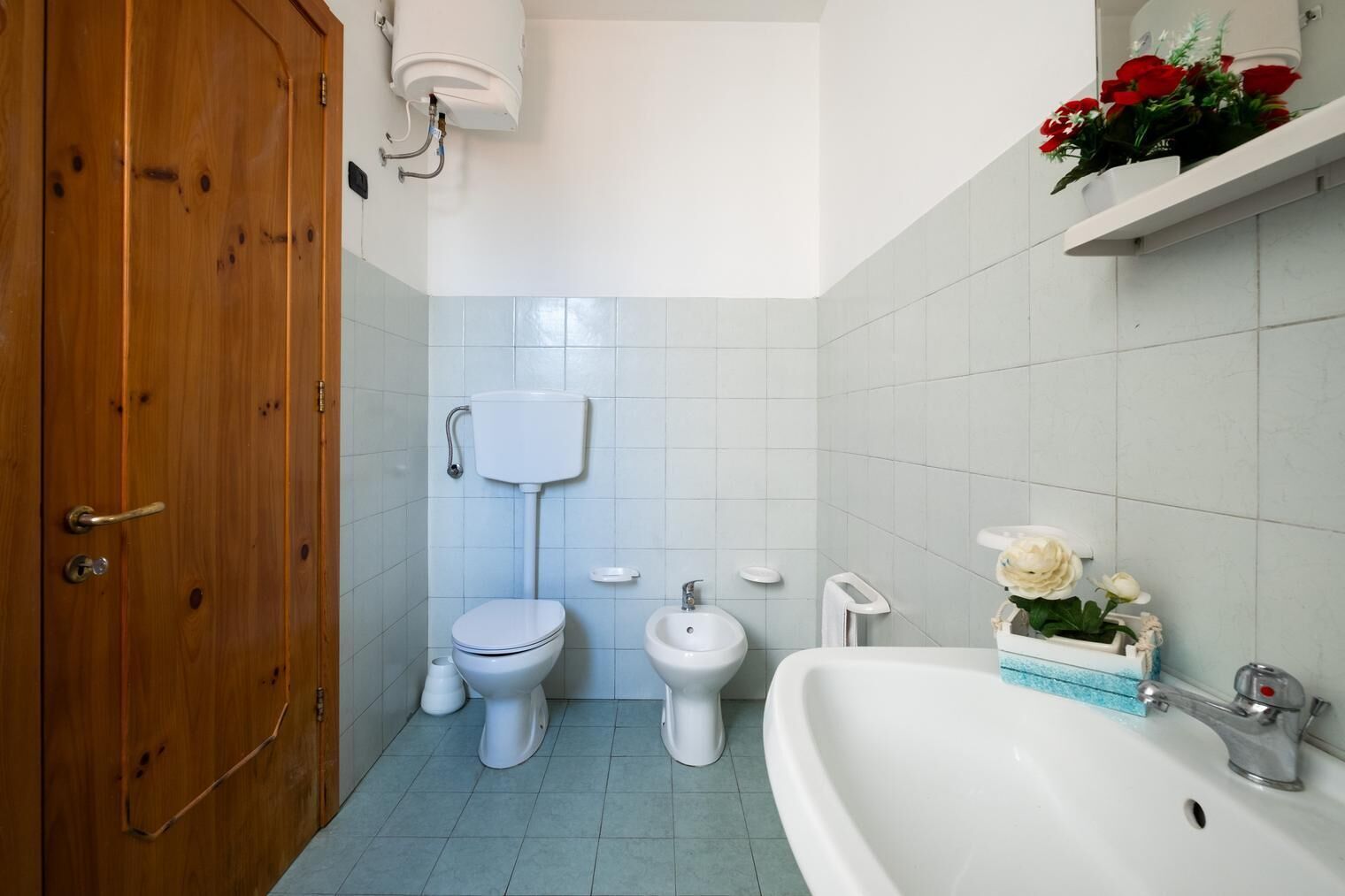 A bathroom with a toilet, bidet, and sink.
