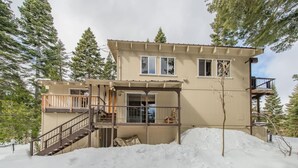 A two-story building with a wooden deck and a staircase leading to the upper level. - Mahogany by Avantstay Snowbird Cabin w Full Chamberlands Access (Homewood)