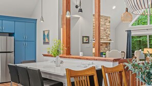 A modern kitchen with a large island, blue cabinets, and wooden accents.