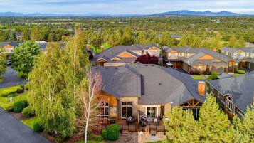 A residential area with multiple houses, well-maintained lawns, and a clear view of the surrounding landscape.